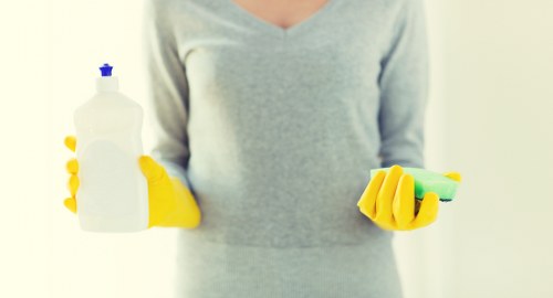 Trained carpet cleaner using protective gloves and safe cleaning methods